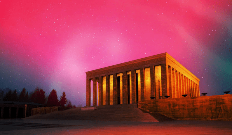 Gök yüzünde pastel tonlarında ışıkların olduğu bir atmosferin altında, Anıtkabir'in gece görüntüsü.